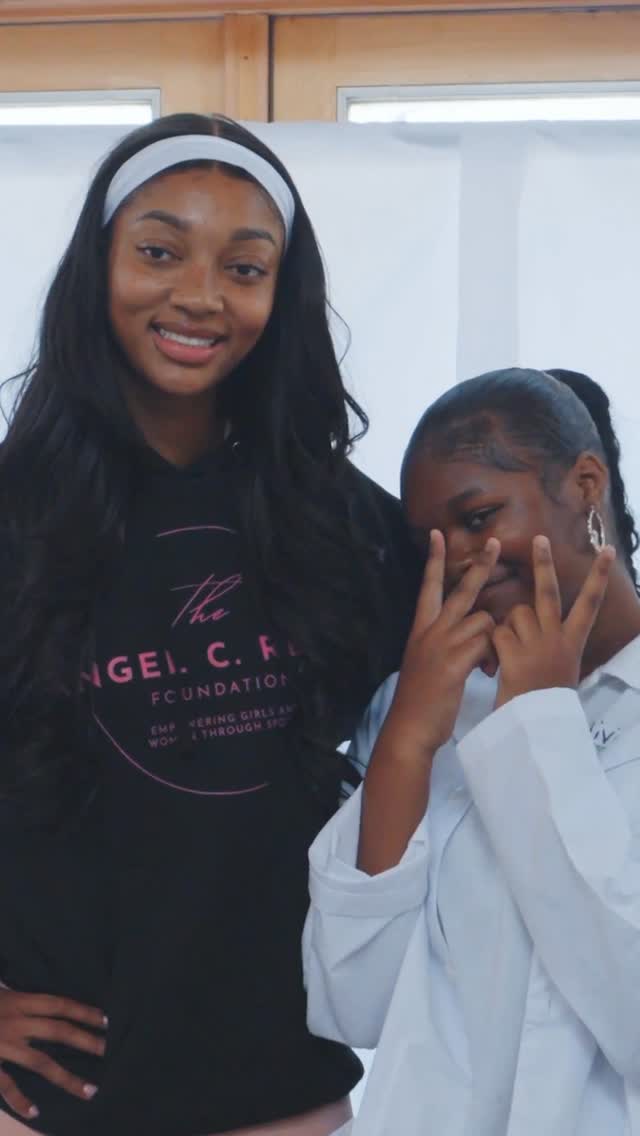 Angel Reese in her Angel C. Reese Foundation hoodie alongside a young foundation participant