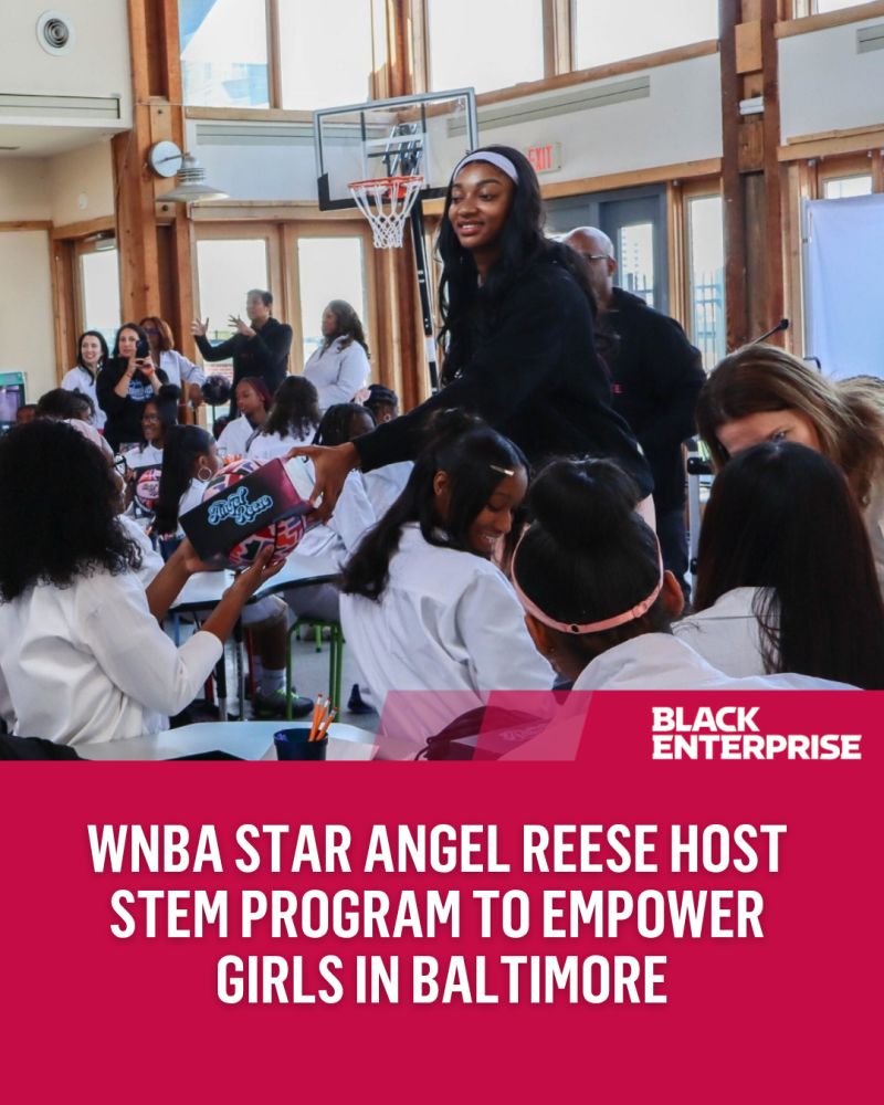 Angel Reese hands a basketball to a girl at her STEM camp at Crossroads Middle, Baltimore